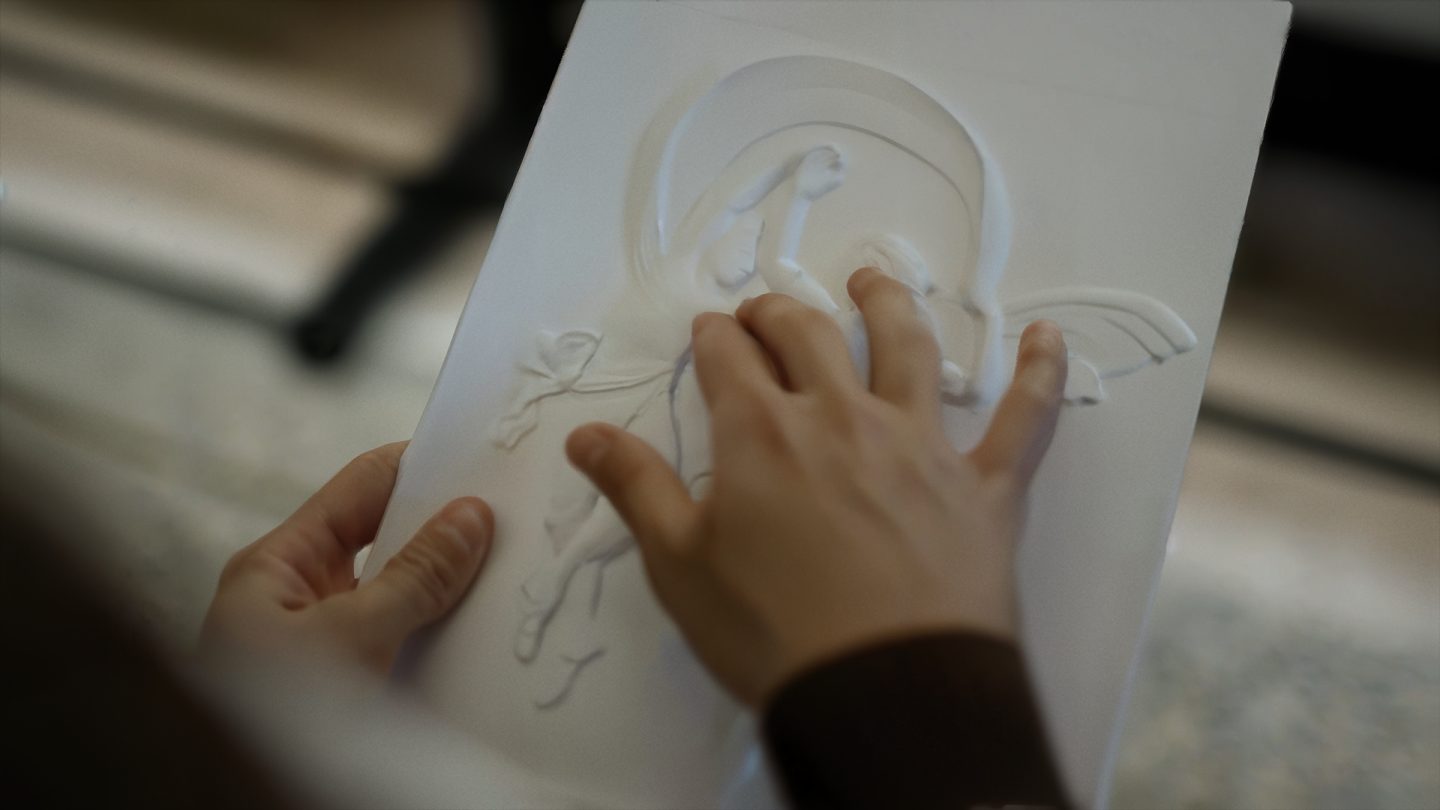 Immagine di una mano che tocca un'opera d'arte