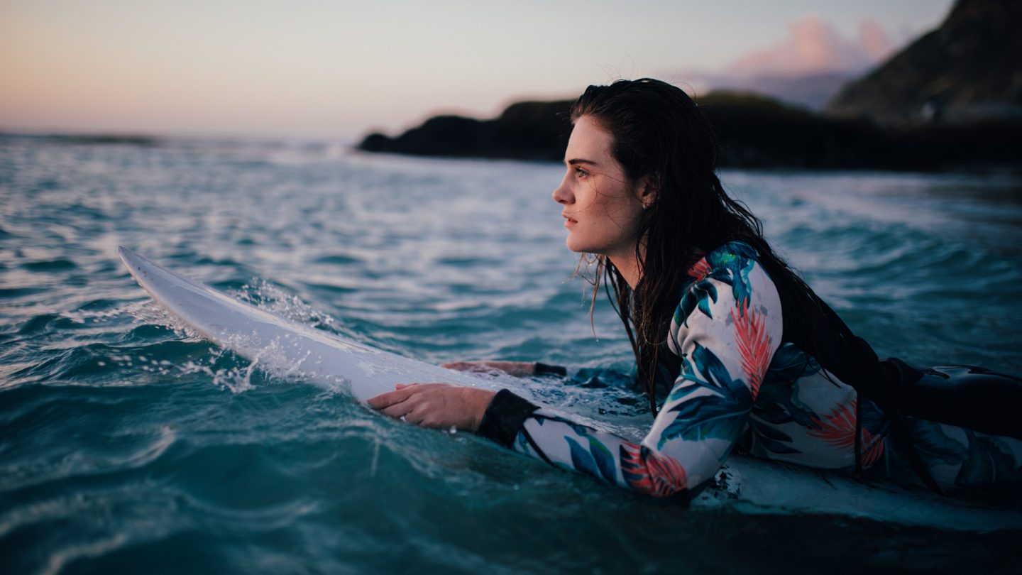 Immagine di una ragazza su una tavola da surf in mano